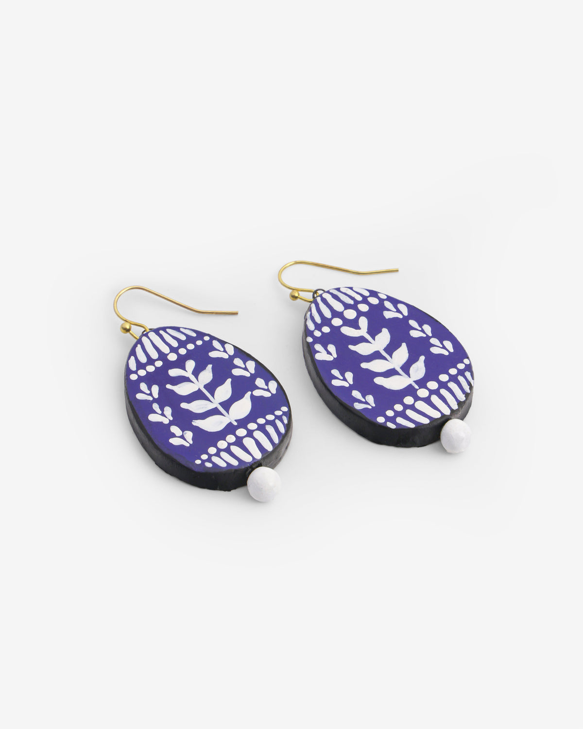 Hand-painted indigo and white floral clay dangle earrings with brass hooks